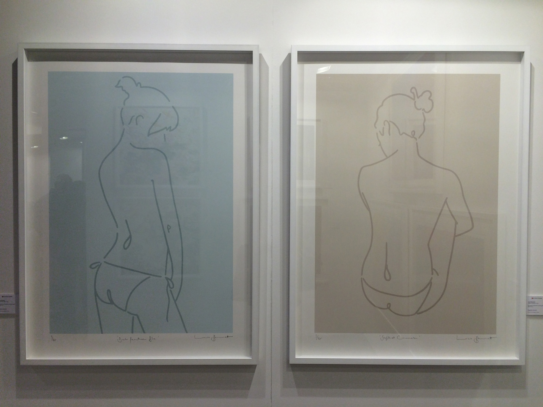 Two minimalist line-art nude prints framed in white